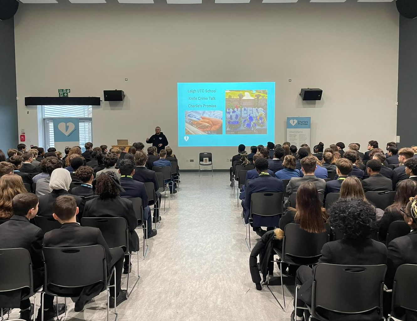 A hall of students watching a presentation